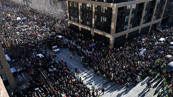 Thousands of protesters fill what can be seen from above of two wide city streets in downtown Minneapolis