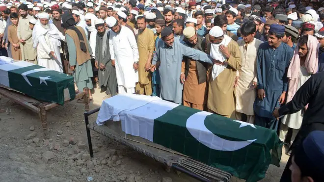 Pakistan bayrağına sarılmış cenazeler, geniş katılımlı bir törende görünüyor.