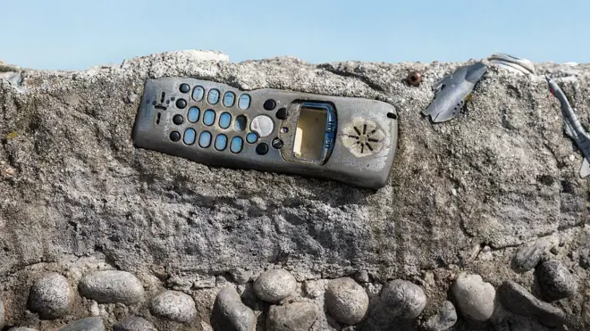 Teléfono antiguo incrustado en una capa de hormigón