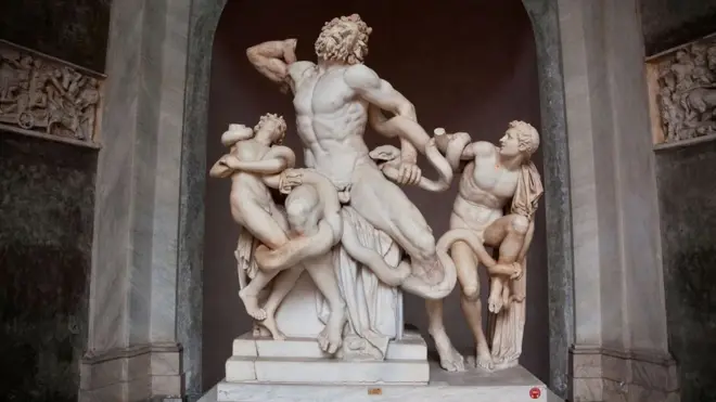 Две морске змије оштрих зуба увијају се око намученог тројанског свештеника Лаокоона и његових невиних синова