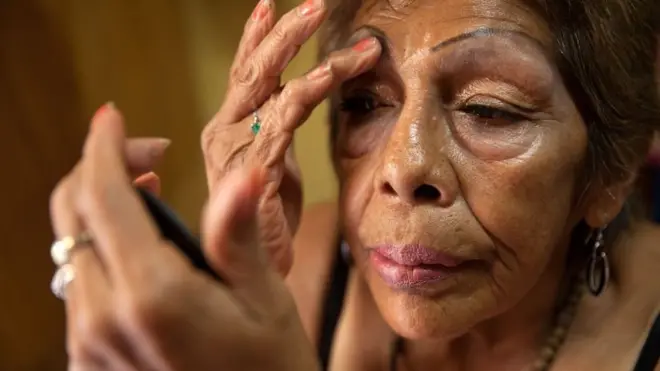 कासा जोशेक्वेत्ज़ल में रहने वाली लुशीता अपने बेडरूम में मेकअप लगा रही हैं.