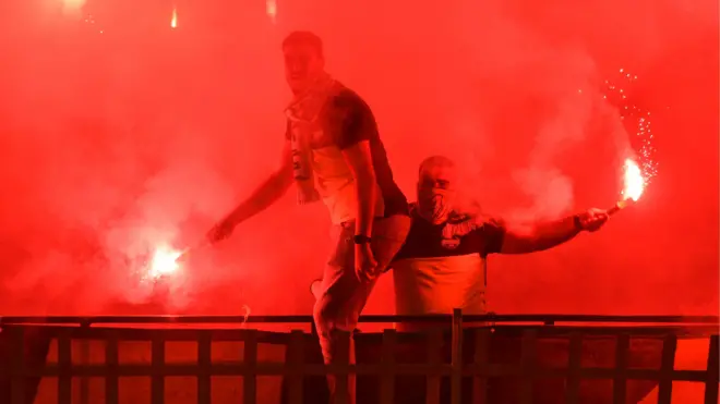 Football fans with lit flares