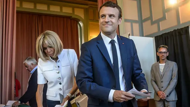 French President Emmanuel Macron (R) votes with his wife Brigitte Trogneux in Le Touquet, northern France, 11 June 2017