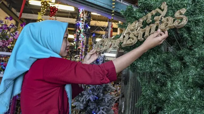 Pedagang menata barang pernak-pernik natal di Pasar Asemka, Jakarta, Jumat (20/12/2019). Pernak-pernik natal mulai dari hiasan hingga pohon natal tersebut dijual dari harga Rp20.000 hingga Rp15,9 juta.