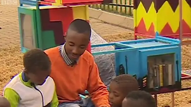 Хлопець читає книжку з дітьми