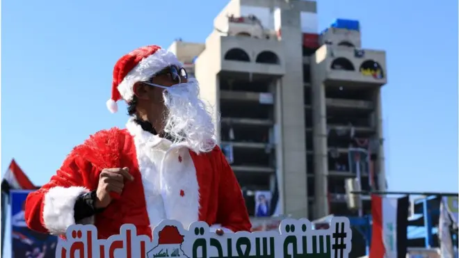 ناشط عراقي يرتدي ملابس "سانتا كلوز" للتسرية عن المتظاهرين المحتشدين في ساحة التحرير، وسط بغداد