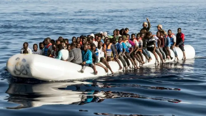 A picture taken on June 27, 2017 shows Libyan coast guardsmen standing in a dinghy carrying illegal immigrants during a rescue operation of 147 people who were attempting to reach Europe