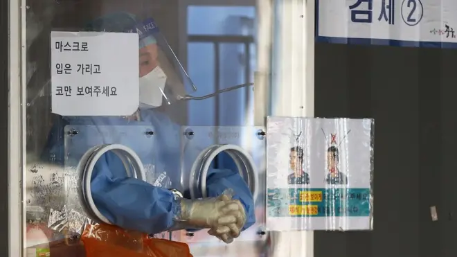 12일 서울역광장에 마련된 코로나 19 임시선별검사소에서 의료진이 두 손을 마주 잡고 언 손을 녹이고 있다