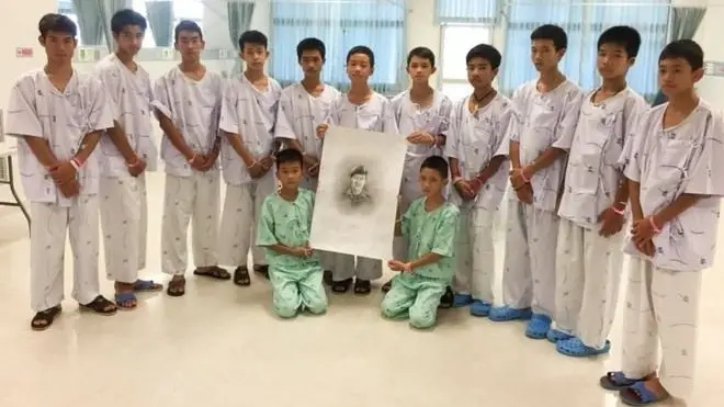 12명의 태국 소년들과 코치는 구조 중 목숨을 잃은 사만 푸난의 초상화와 함께 사진을 찍었다