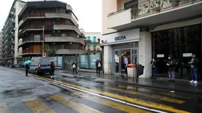 Sicilya'da bir dükkan önünde kuyrukta bekleyenler