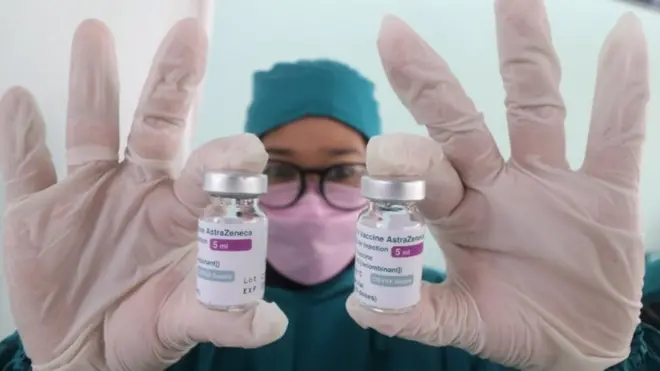 Petugas kesehatan memperlihatkan botol vaksin COVID-19 AstraZeneca saat vaksinasi bagi pedagang di pasar tradisional Gringging, Kediri, Jawa Timur, Kamis (1/4/2021).