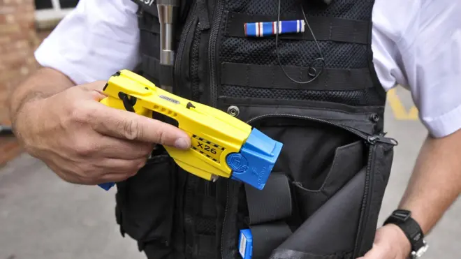 شرطي يحمل مسدسا صاعقا