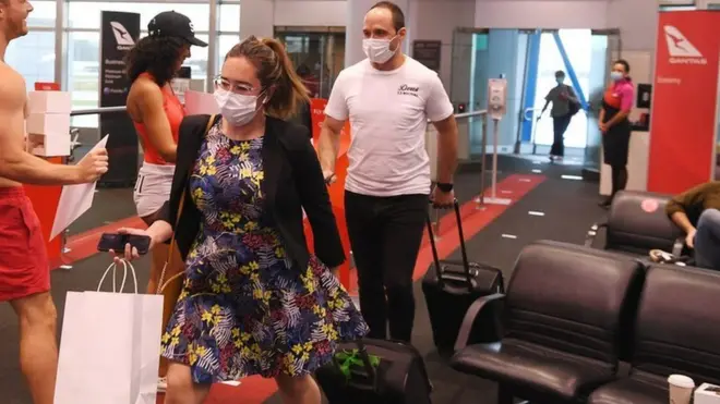 Passengers are welcomed as they arrive in Sydney on a Qantas flight from Melbourne