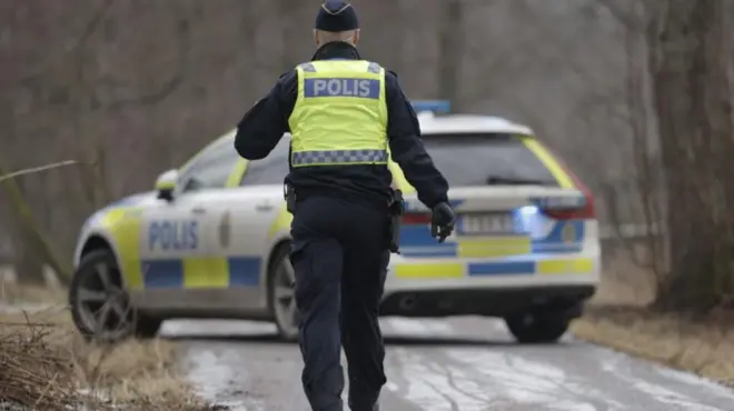 Полицейский на фоне полицейского автомобиля