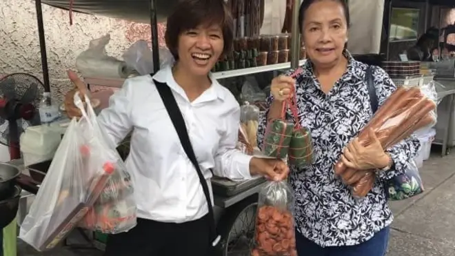 Chị Đông (áo trắng) và khách tại xe hàng của chị ở chợ Samsen, Bangkok