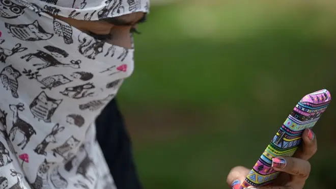 فتاة تنظر إلى هاتفها النقال