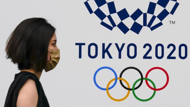 Woman in front of Tokyo 2020 sign