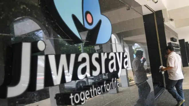 Warga melintas di depan kantor Asuransi Jiwasraya di Jalan Juanda, Jakarta, Rabu (11/12)