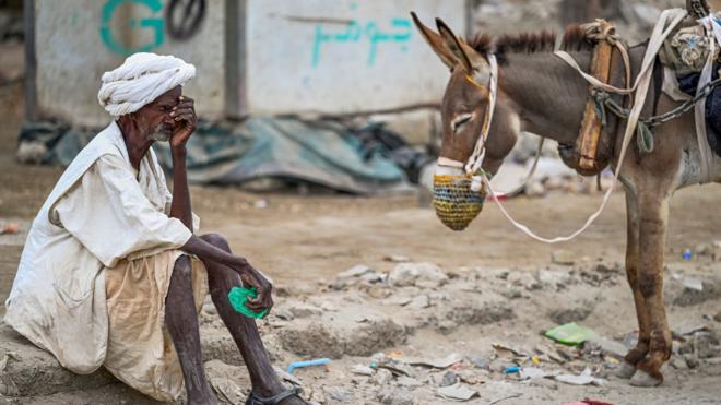 An elderly man waits to refill his donkey-drawn water tank during a water crisis in Port Sudan in war-torn Sudan on 9 April, 2024.