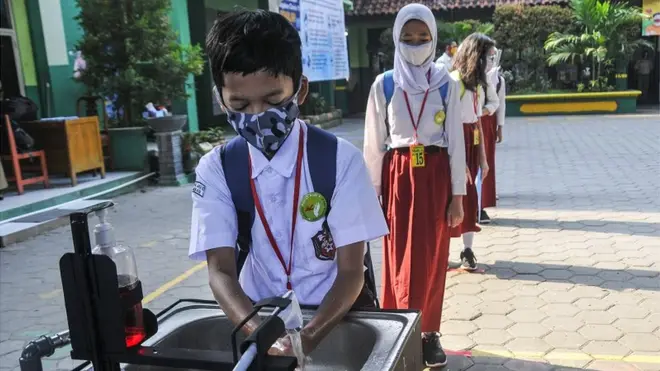 Sejumlah murid antre mencuci tangannya sebelum memasuki ruang kelas di SD N Negeri 6, Bekasi, Jawa Barat, Senin (3/8/2020). Pemerintah setempat memberikan izin kepada enam sekolah untuk melakukan uji coba pembelajaran tatap muka selama satu bulan.