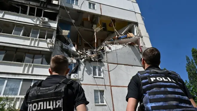 Officials inspect damage to a building in Kharkiv