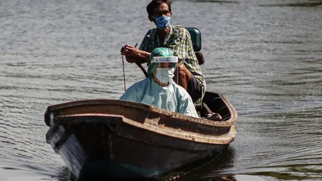 ชาวบ้านขับเรือพาเจ้าหน้าที่เข้าไปตรวจหาเชื้อชาวบ้านในชุมชนริมน้ำ จ.สมุทรสาคร เมื่อวันที่ 2 ก.ค.