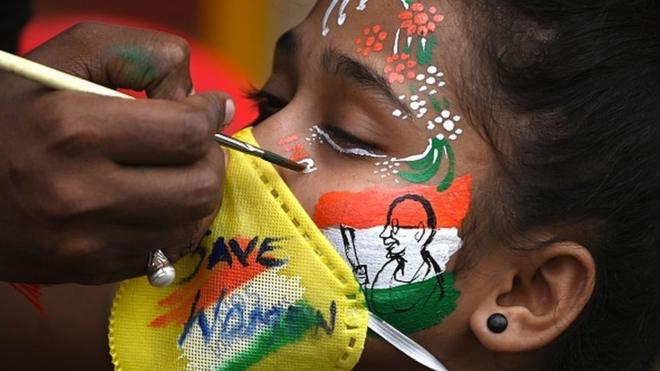 A student gets her face painted to at a protest rally in Mumbai on October 2, 2020