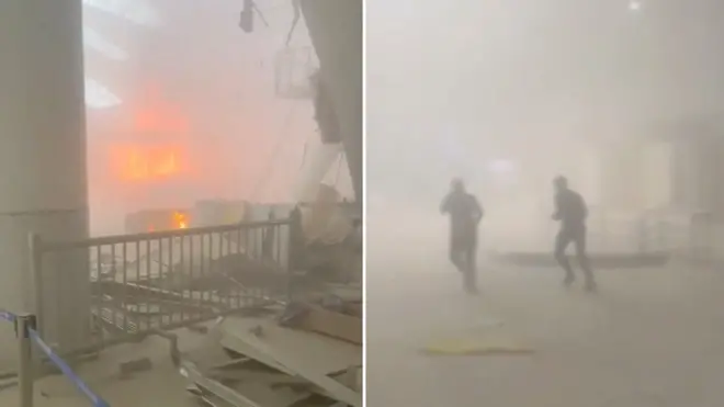 Varias personas corren entre el humo de un incendio, tras los ataques iraníes, según el Ministerio de Relaciones Exteriores, en el Aeropuerto Internacional de Kuwait, en la ciudad de Kuwait.
