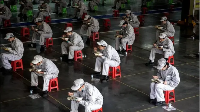 డాంగ్‌ఫెంగ్ ఫెంగ్‌షెన్ ప్లాంటులో పరస్పరం రెండు మీటర్ల దూరంలో కూర్చుని భోజనం చేస్తున్న ఉద్యోగులు