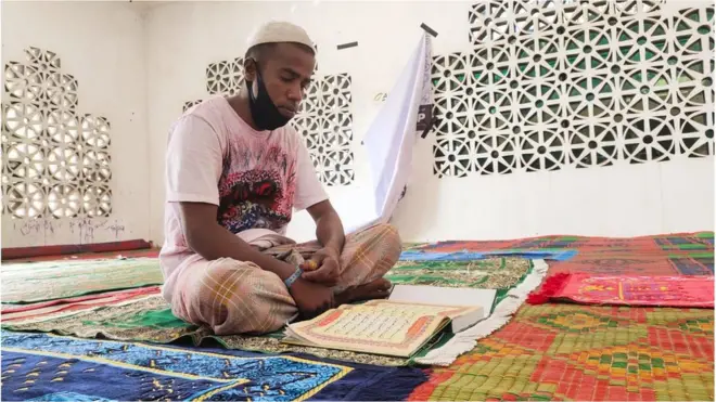 Muhammad Yusuf sedang membaca Quran di musala tempat penampungan di Lhokseumawe, Aceh.