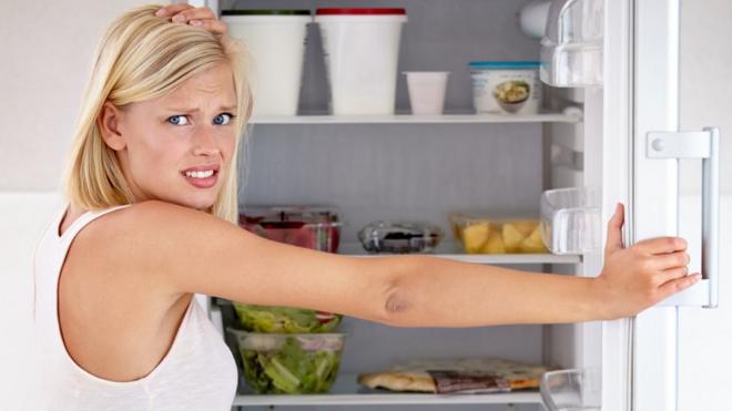 Woman opening fridge