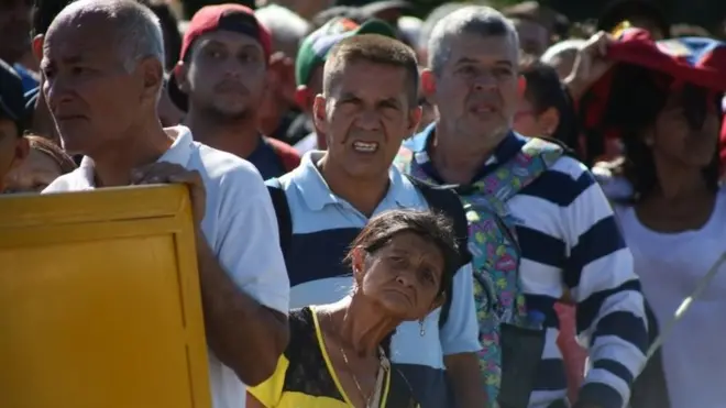 People wait to cross the Colombian-Venezuelan border over the partially opened Simon Bolivar international bridge