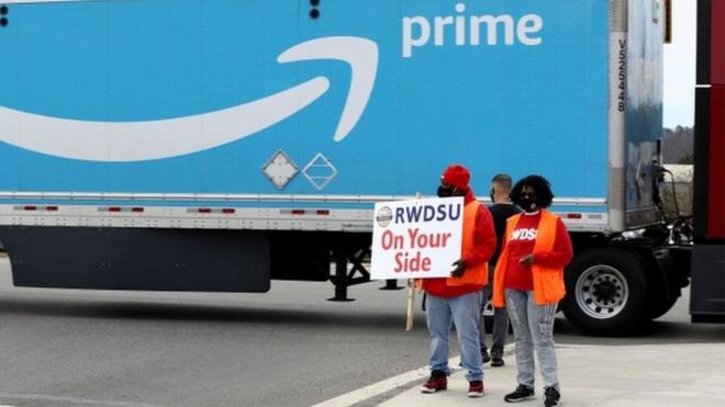 People hold a banner at the Amazon facility as members of a congressional delegation arrive to show their support for workers who will vote on whether to unionize, in Bessemer, Alabama, U.S. March 5, 2021