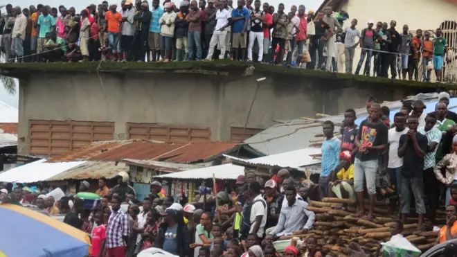 Sierra Leoneans gather dey look as the burial for the hundreds of people wey die, dey go on for Paloko cemetery