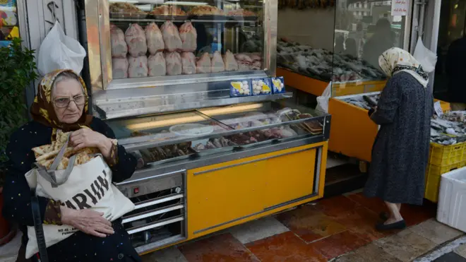 یک خانم سالخورده جلوی یک قصابی در تهران