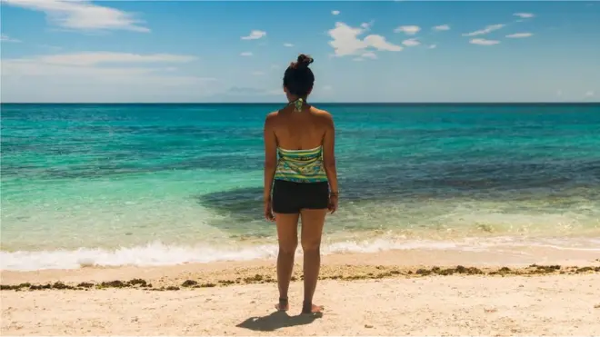 Una mujer frente a la playa