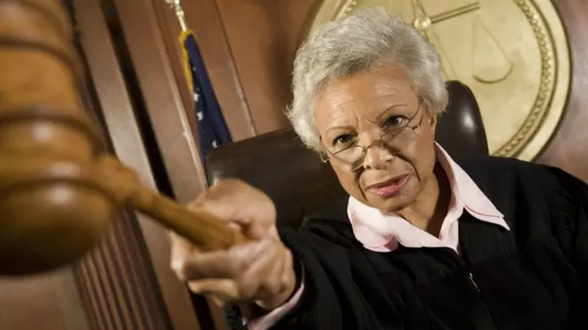 A judge pointing her gavel