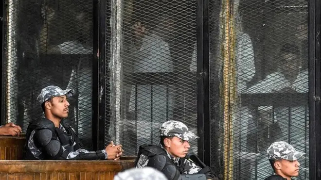 Defendants look out into the court in Cairo