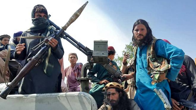 塔利班战士坐在拉格曼省某街道上的一辆汽车上