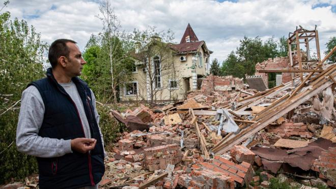 The owner of the building surveys the ruins of his building on the outskirt of the separatist region of Donetsk, 19 May
