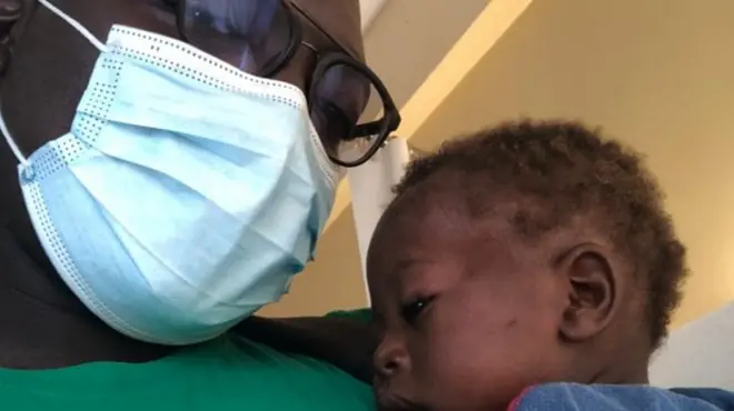 Le bébé avec le Dr Yonta qui la porte sur sa poitrine