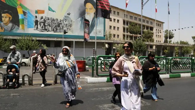 Wомен wалк ин ан Ираниан стреет wитхоут а хијаб