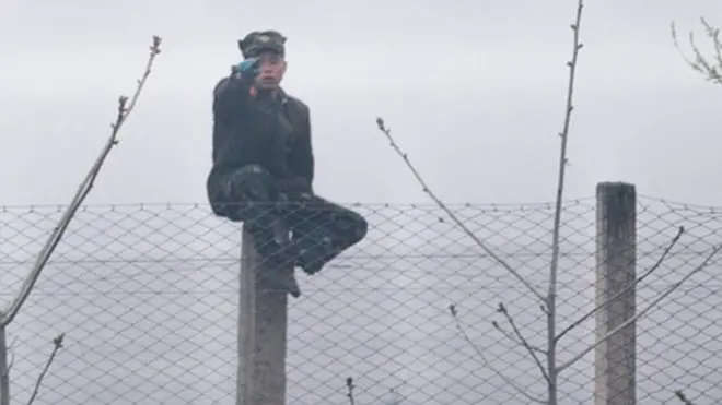 ทหารเกาหลีเหนือนั่งอยู่ที่ชายแดนระหว่างเกาหนีเหลือและจีน