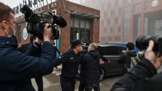 ماموران امنیتی چین به محض ورود کاروان خودروهای سازمان بهداشت جهانی روزنامه‌نگاران را از صحنه دور کردند