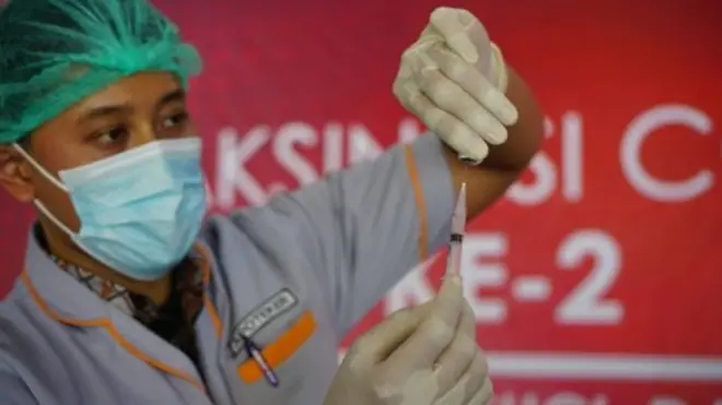 Petugas mengambil cairan vaksin COVID-19 menggunakan spet injeksi saat pelaksanaan vaksinasi gelombang 2 di Tulungagung, Jawa Timur, Kamis (11/2/2021).