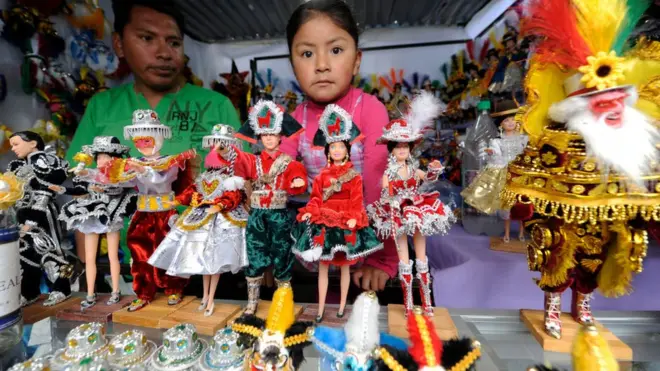 Grandes y chicos hacen los recorridos rituales en "La Alasita" para adquirir e intercambiar figuritas vinculadas a la deidad aimara de Ekeko.