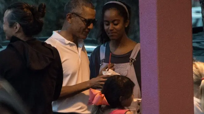 Obama bersama salah satu puterinya, Malia, dalam sebuah liburn di Hawai, tahun lalu.