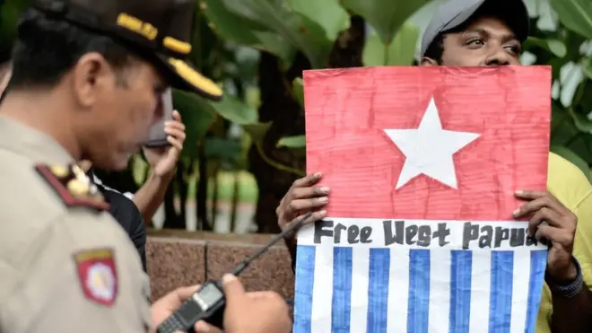 Seorang pengunjukrasa membawa simbol bendera Bintang Kejora menuntut pemisahan Papua dari Indonesia dalam demo pada April 2017 di Jakarta.
