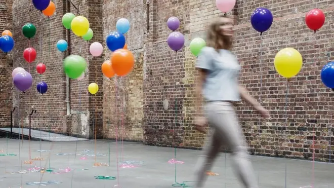 Balonlarla yürüyen kadın