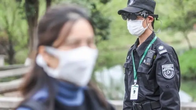 浙江的一个公园里，保安人员用AR（扩增虚拟实境）设备测量公园游客的体温。